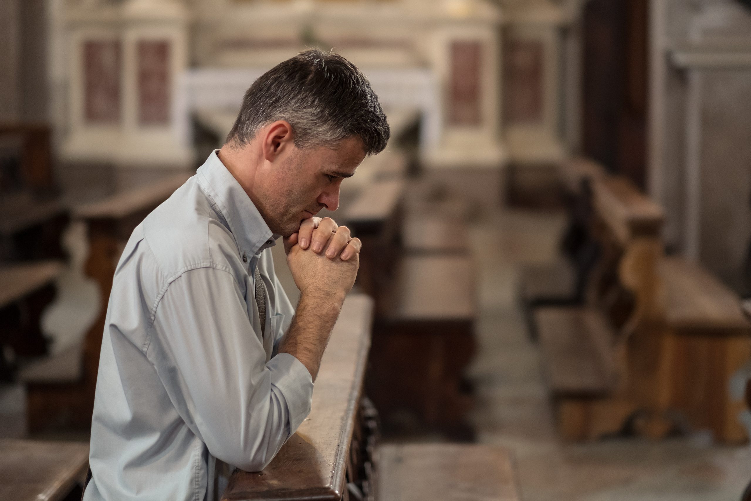 man kneels in prayer