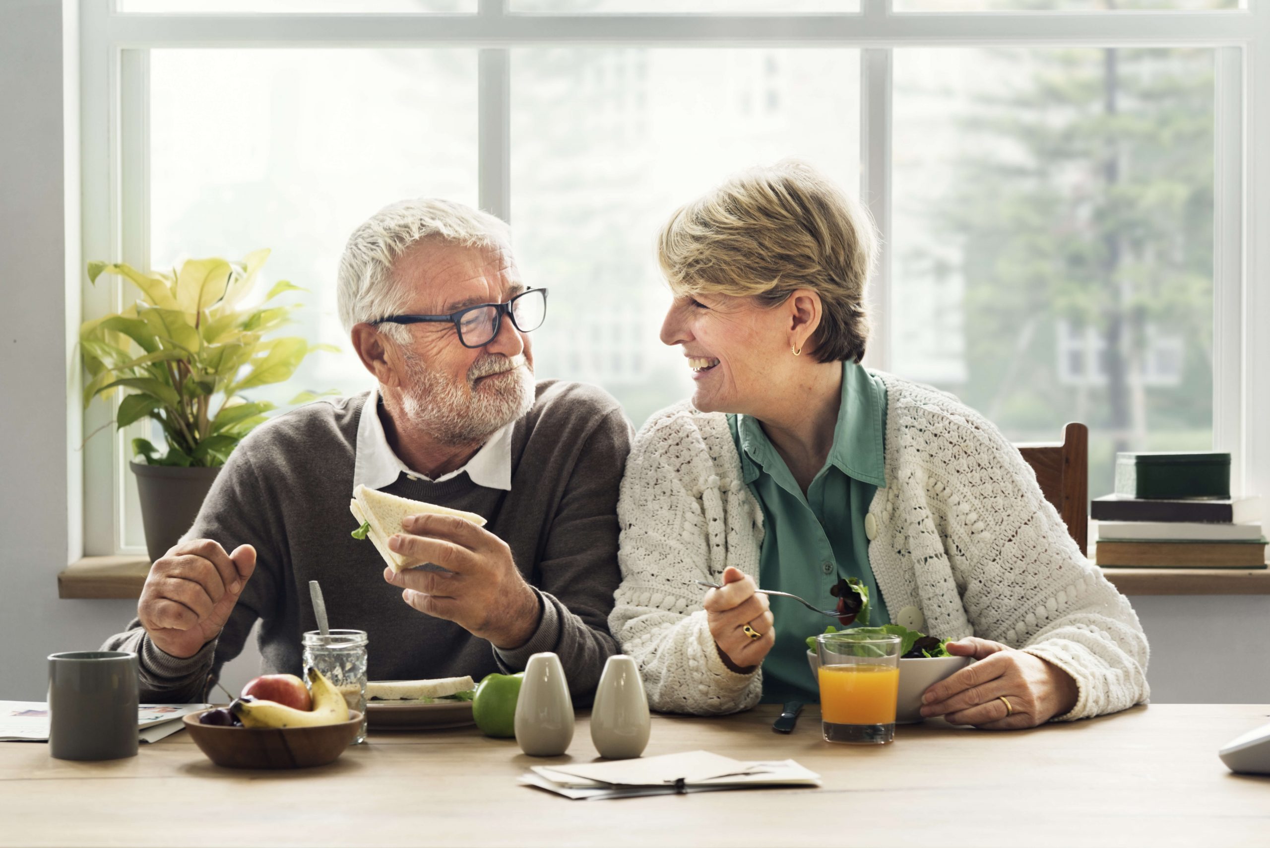 older couple happily share breakfast