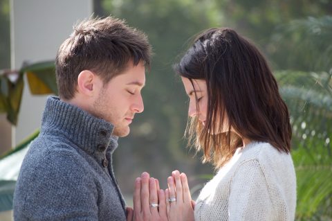 man and woman pray face to face