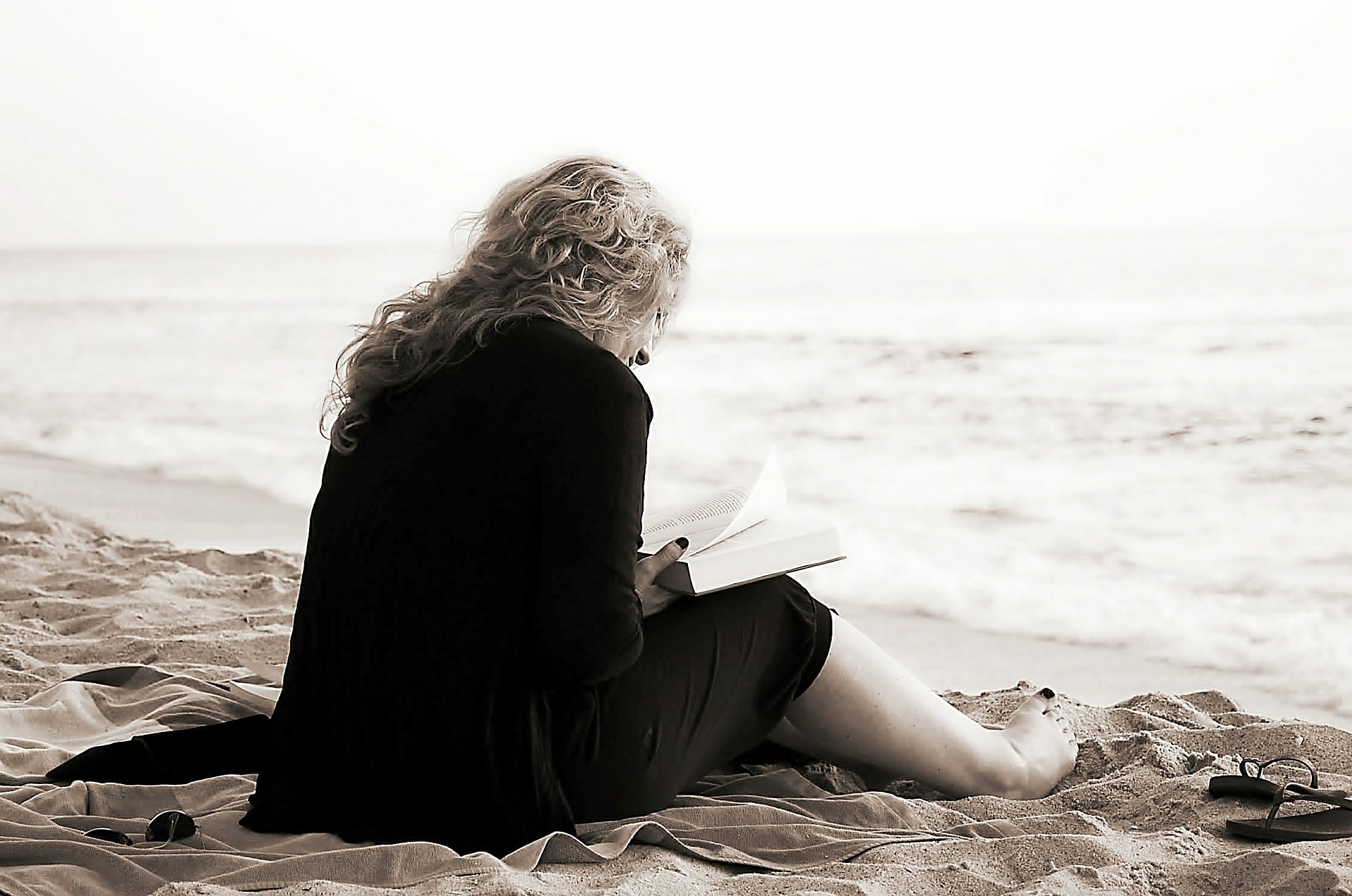 girl reads Bible on beach