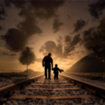 father and son walking on railroad tracks